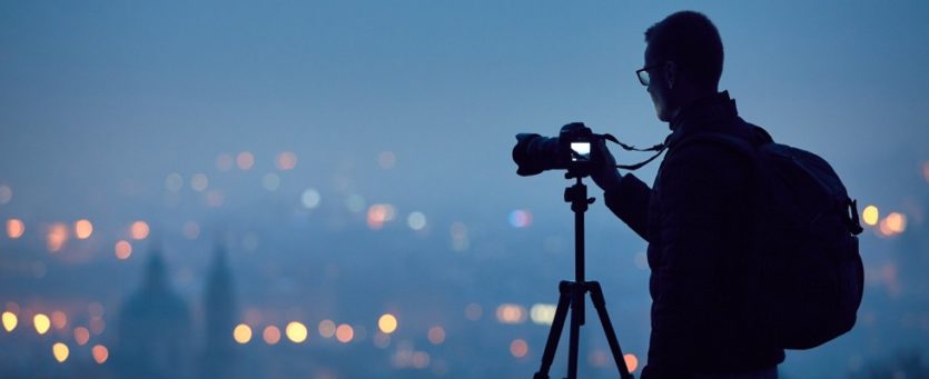 Fotograf vor City-Skyline Wenn es draußen dunkel ist, lassen sich viele Lichtquellen beim Fotografieren nutzen.