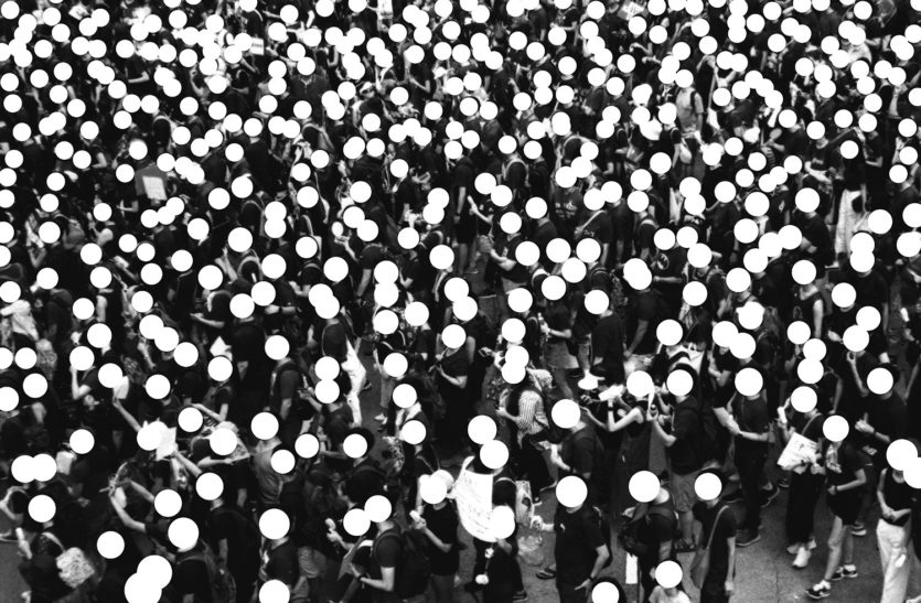 Menschenmenge in Hong Kong, alle Köpfe wurden mit weißen Kreisen unkenntlich gemacht