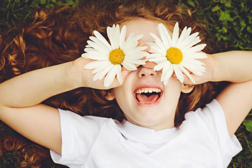Kind mit Blumen vor den Augen