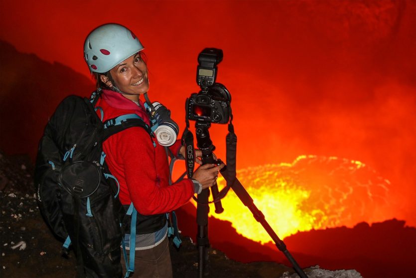 Ulla Lohmann mit ihrer Fotoausrüstung am Krater eines Vulkans