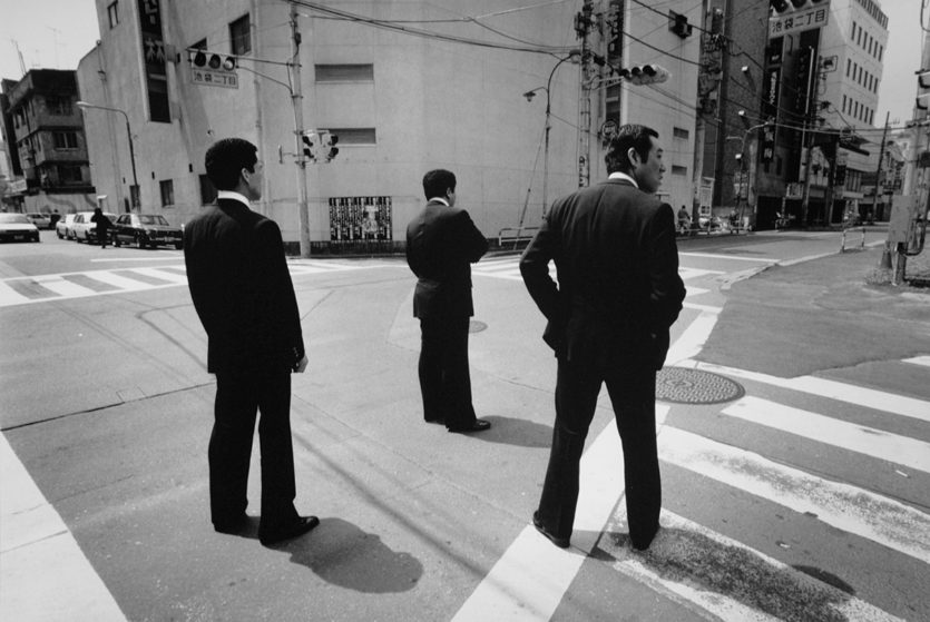 Drei Männer warten auf der Straße. Schwarzweißfotografie