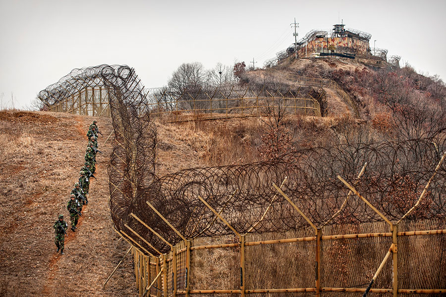 Südkoreanische Soldaten patrouillieren innerhalb der DMZ. Im Hintergrund ein südkoreanischer Wachposten