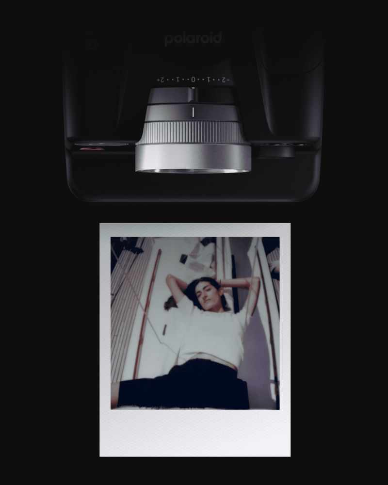Ein Sofortbild mit dem Portrait einer Frau auf einem Segelboot liegt vor einer Polaroid I-2