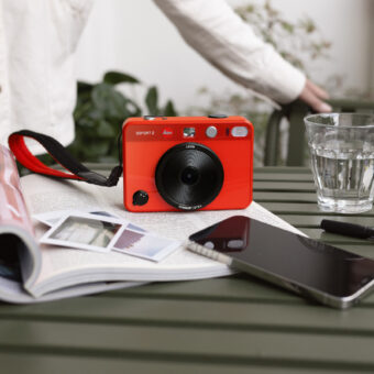 Leica Sofort 2 in Rot auf einem Tisch im Freien