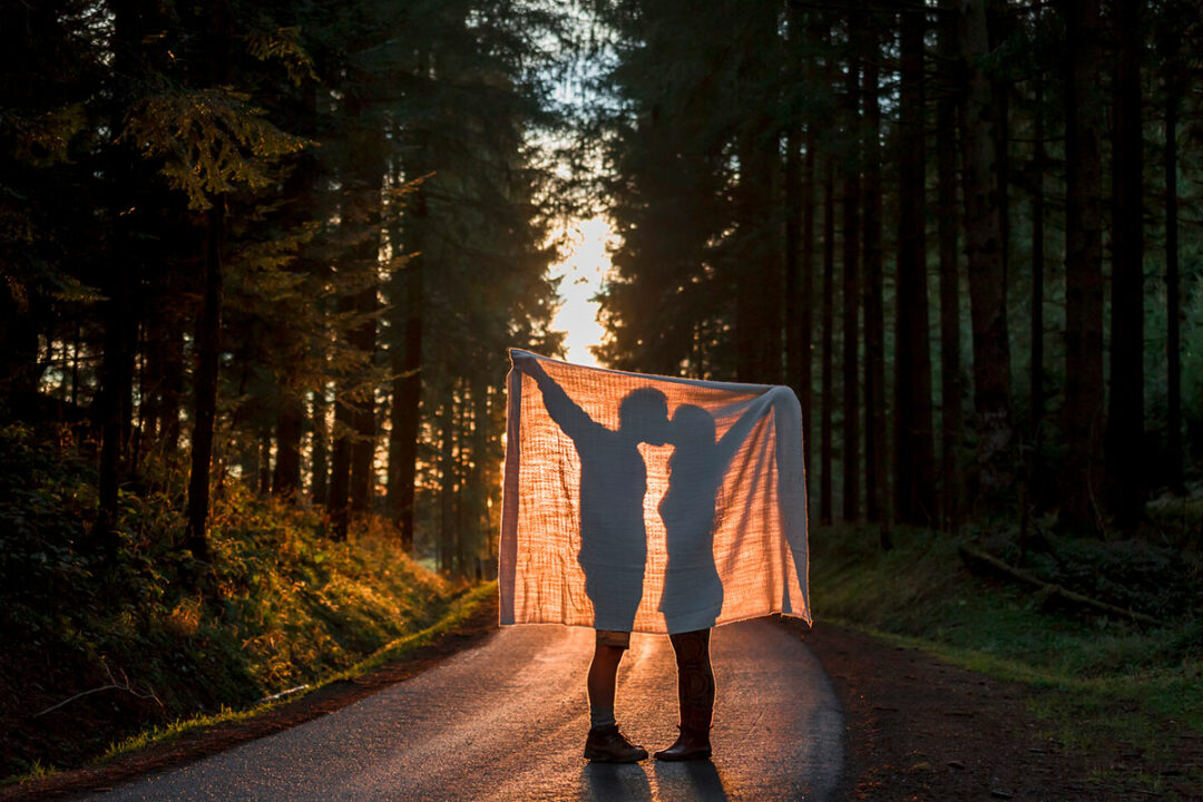 Silhouette eines küssenden Paars im Wald