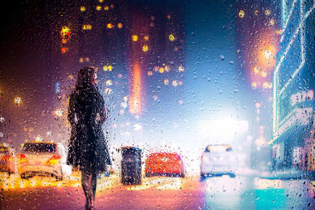 Nachtfotografie: Frau auf Straße bei Nacht mit Regen