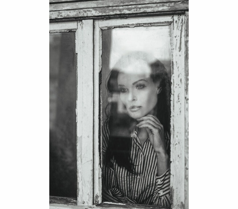 Schwarweiß-Porträt Frau am Fenster